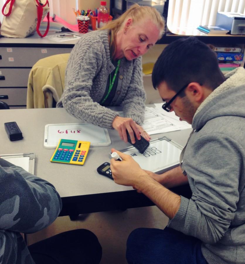 Instructor Joscelyn Wildgen teaches ESE student John Rivera about square roots in an interactive math lesson.