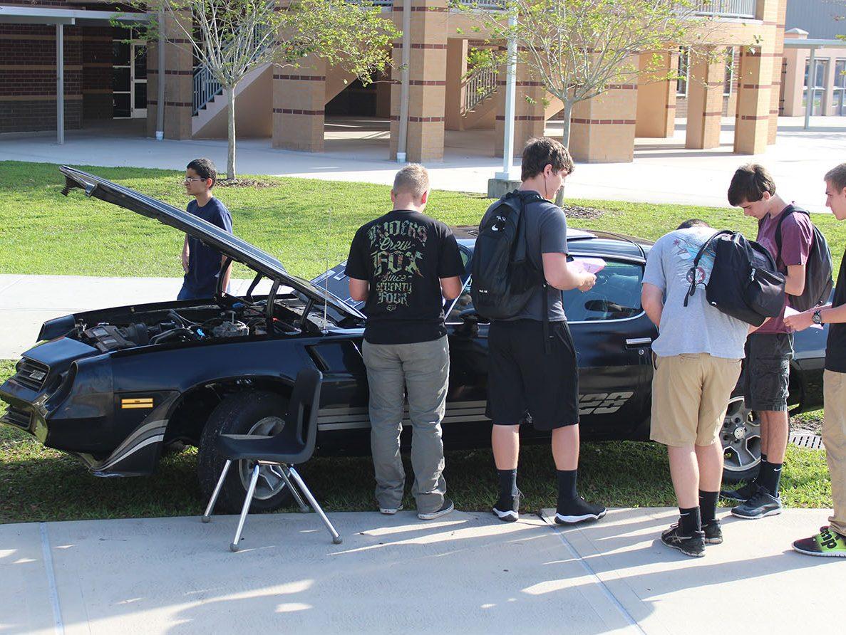 Students learn about senior Esteban Felicianos engine installation project.
