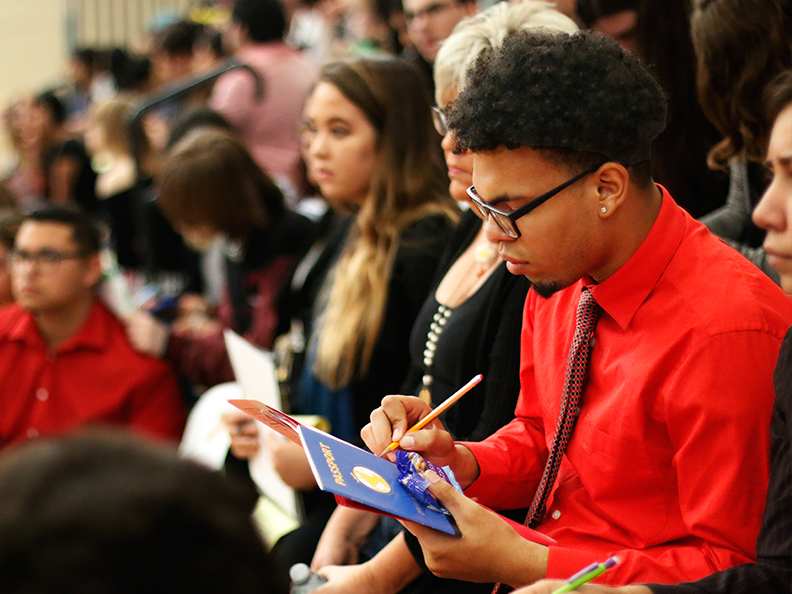 Senior Victor Castro takes notes during the Career Day event on Feb. 8 at the RWL gym.