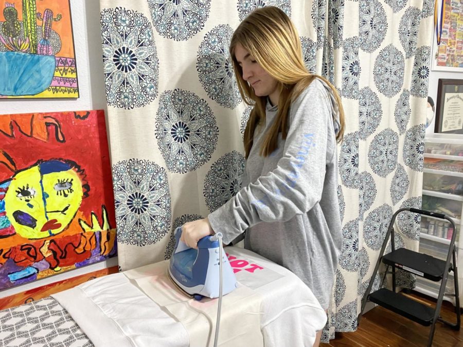 Sophia Piriano, 10, irons on her designs on a hoodie to sell on her website.