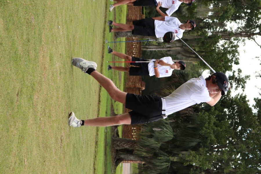 Tyler McGrath hits the ball, starting the first match of the meet against Hagerty High School.