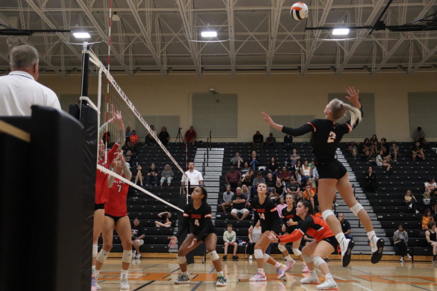 Kylie+OBrien+hits+the+volleyball+over+the+net+into+the+other+teams+side.