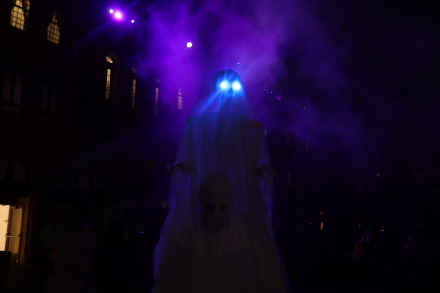 A scare actor looms above the Halloween Horror Nights guests, jumping out at the people passing by.