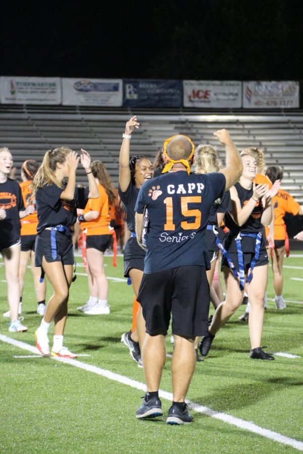 Physics teacher Chris Capp cheers with the girls that he is coaching on the powderpuff team.