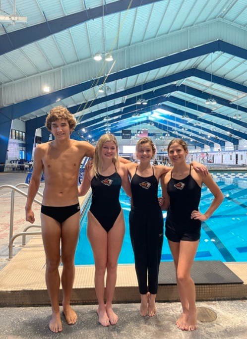 Carson Powers, Chloe Dunn, and Molly Connell pose with a friend at a swim meet.