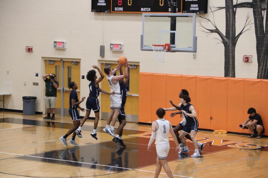 Senior Grady King jumps past Lake Howell defenders to make a basket for the Lions.