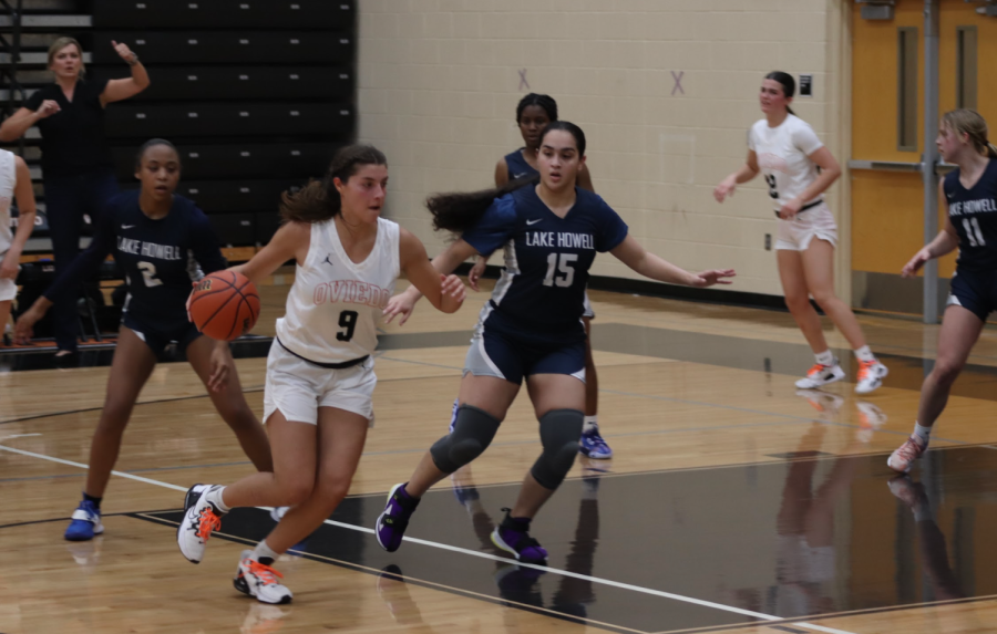 Senior center Carmen Longhurst dribbles the ball past a Lake Howell defender.