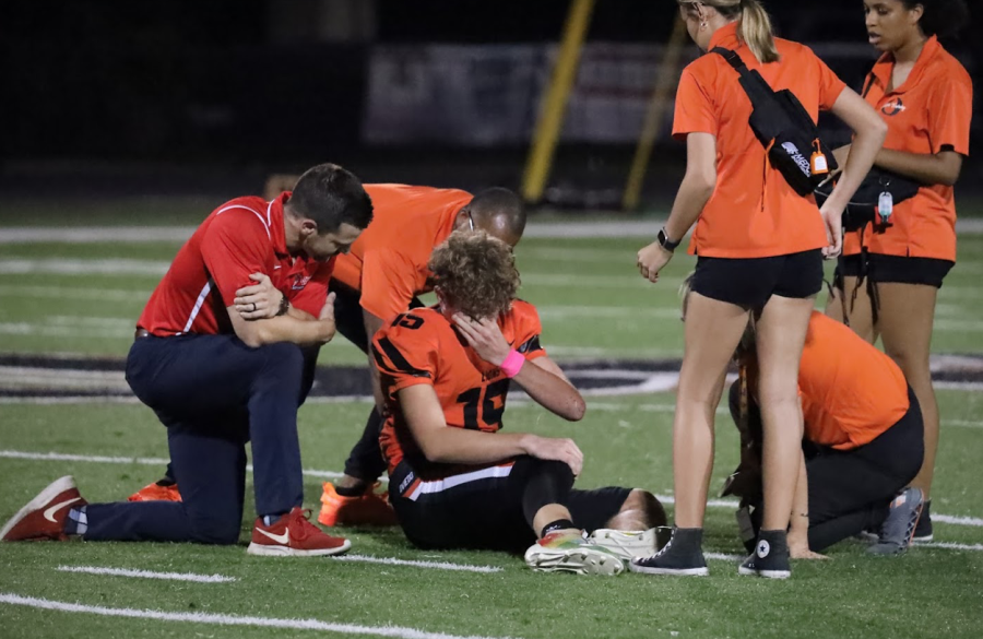 Junior+quarterback+Jackson+Latour+receives+on-field+medical+attention+from+athletic+trainers+after+a+big+hit.