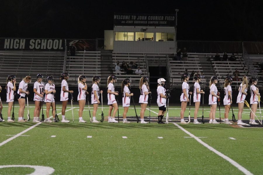 The Oviedo Lacrosse Lady Lions stand at attention before the game.