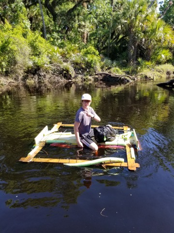 Sam poses as he floats down the river on his homemade raft.