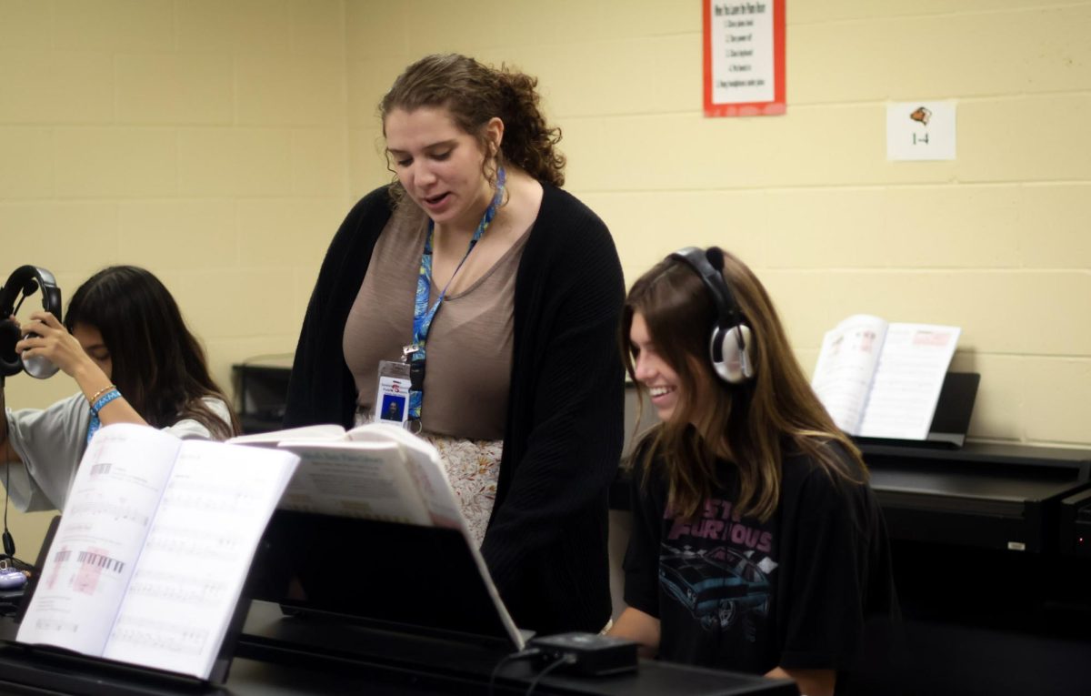 Morgan Watts helps a student read sheet music. Watts came from an internship at Lake Brantley High School and is overjoyed at Oviedo High Schools environment.
