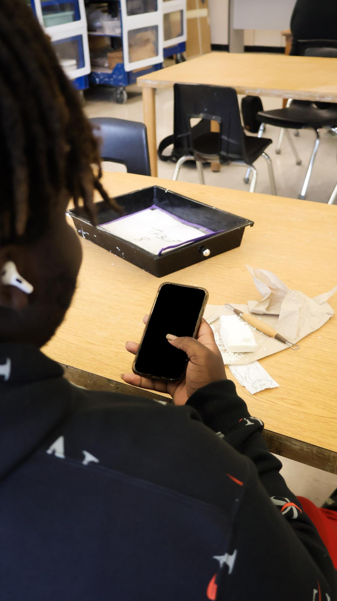 A student uses their phone during their art class under explicit teacher permission.