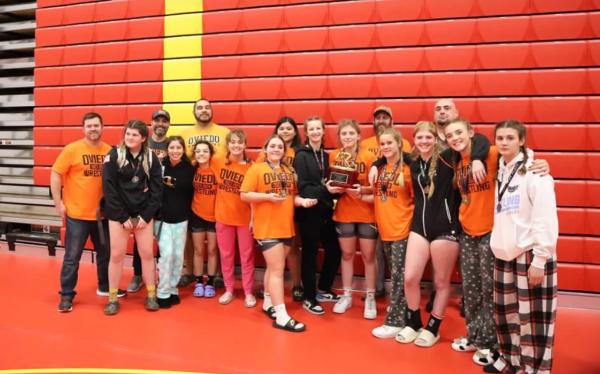 The Oviedo girls varsity wrestling team poses with their first place trophy after winning the Ben Richards Memorial Tournament in Tampa on Dec. 1. This was both the girls and boys teams’ first Individual Bracketed Tournament (IBT) of the season.