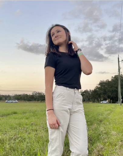 Meredith Kovac poses for the camera in a field. The peaceful energy they show comes from their calm and collected energy that has helped them get through high school and graduate as Valedictorian. 