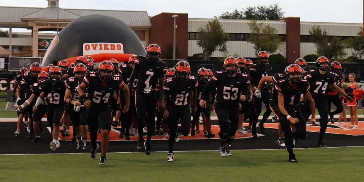 The Oviedo Lions run out of the tunnel before their matchup with the Patriots.