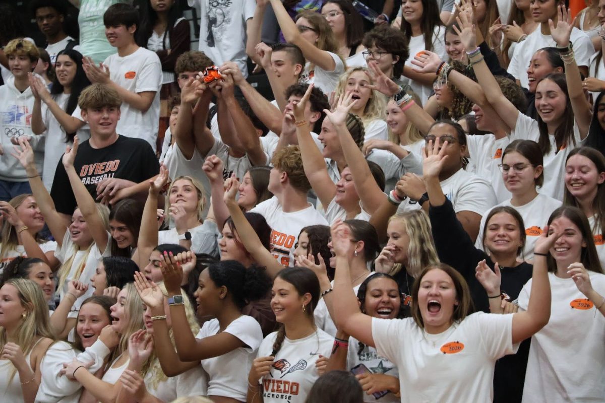 Junior students celebrate the first pep rally of the year with yelling and cheers in their white class shirts.