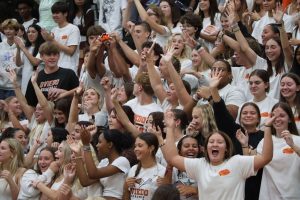 Junior students celebrate the first pep rally of the year with yelling and cheers in their white class shirts.