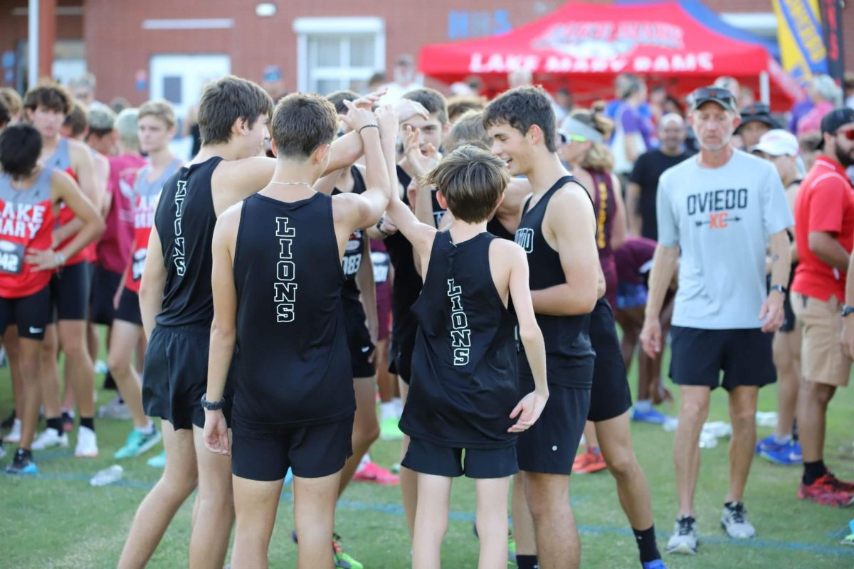 The Oviedo boy's cross country team engages in a pre-meet ritual to hype themselves up for a Friday-night meet at Hagerty High School. 