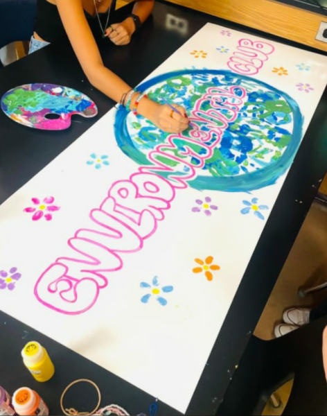 
Students in Oviedo's Environmental Club paint their banner for the Homecoming parade at a club meeting
