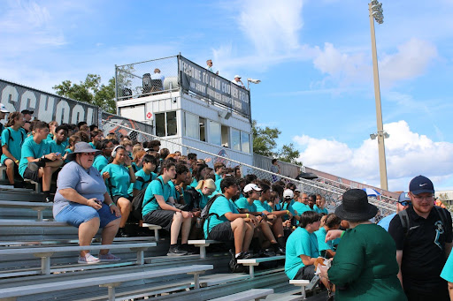 A smaller marching band takes up the stands at FFCC. Coaches, judges, students, and performers alike can be seen supporting those currently on the field. 