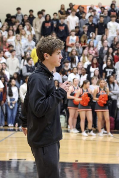 Senior class president Steven Ridder directs winter sports pep rally.