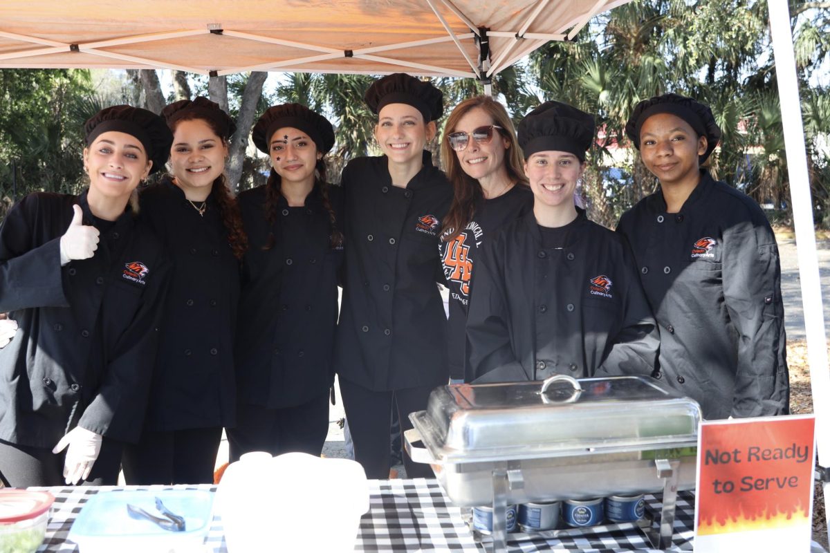 The culinary students representing OHS smile from underneath their tent at the Fire and Ice Chili Cook Off. 
