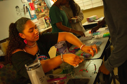 President Natalia Almendarez helps a fellow club member tie a bracelet for Love Week. Almendarez believes in community and assuring everyone feels like a part of the school. "I really like the message that [BSU] stood by and I wanted to be a part of it," Almendarez said