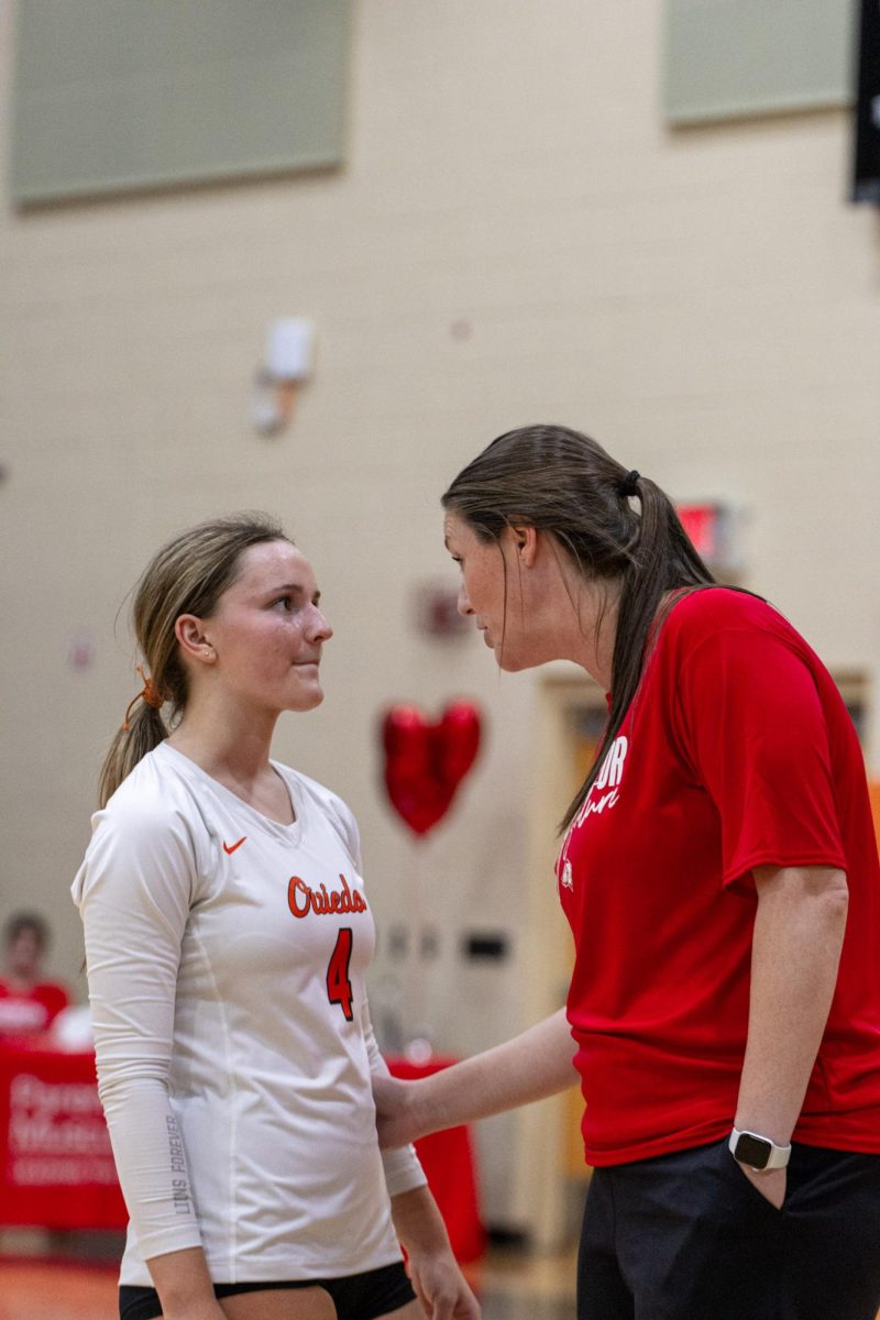 Coach Jennifer Darty giving words of advice to Delaney Sloane, junior.