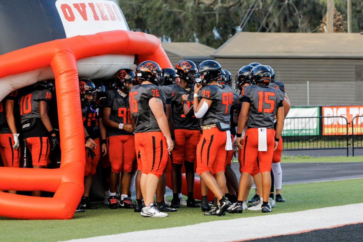 Before the game, the Lions football team prepares to run out of the blow-up Oviedo football helmet.