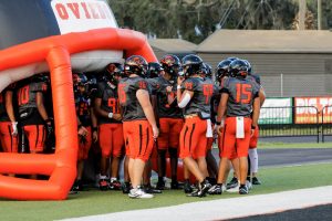 Before the game, the Lions football team prepares to run out of the blow-up Oviedo football helmet.