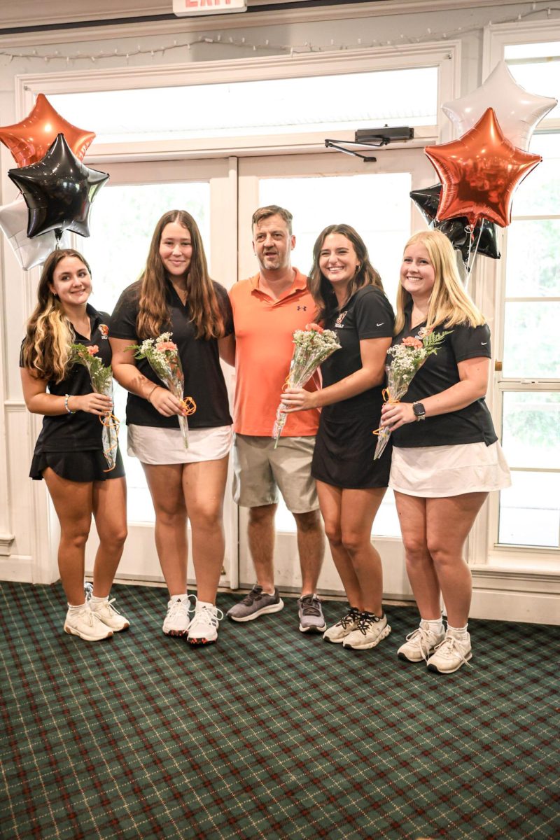 Seniors Kendall Owen, Marley Moore, and Sofia Miller with Coach McKernan on their senior night, celebrating another successful season of golf.