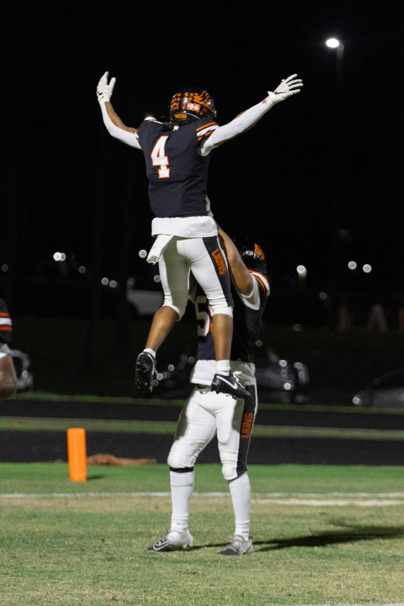 Running back Johnnie Cobbs gets lifted by lineman Sebastian Perez after scoring a touchdown. Cobbs led the team with 72 yards and 2 touchdowns on the ground in the offense’s impressive 55 point showing.