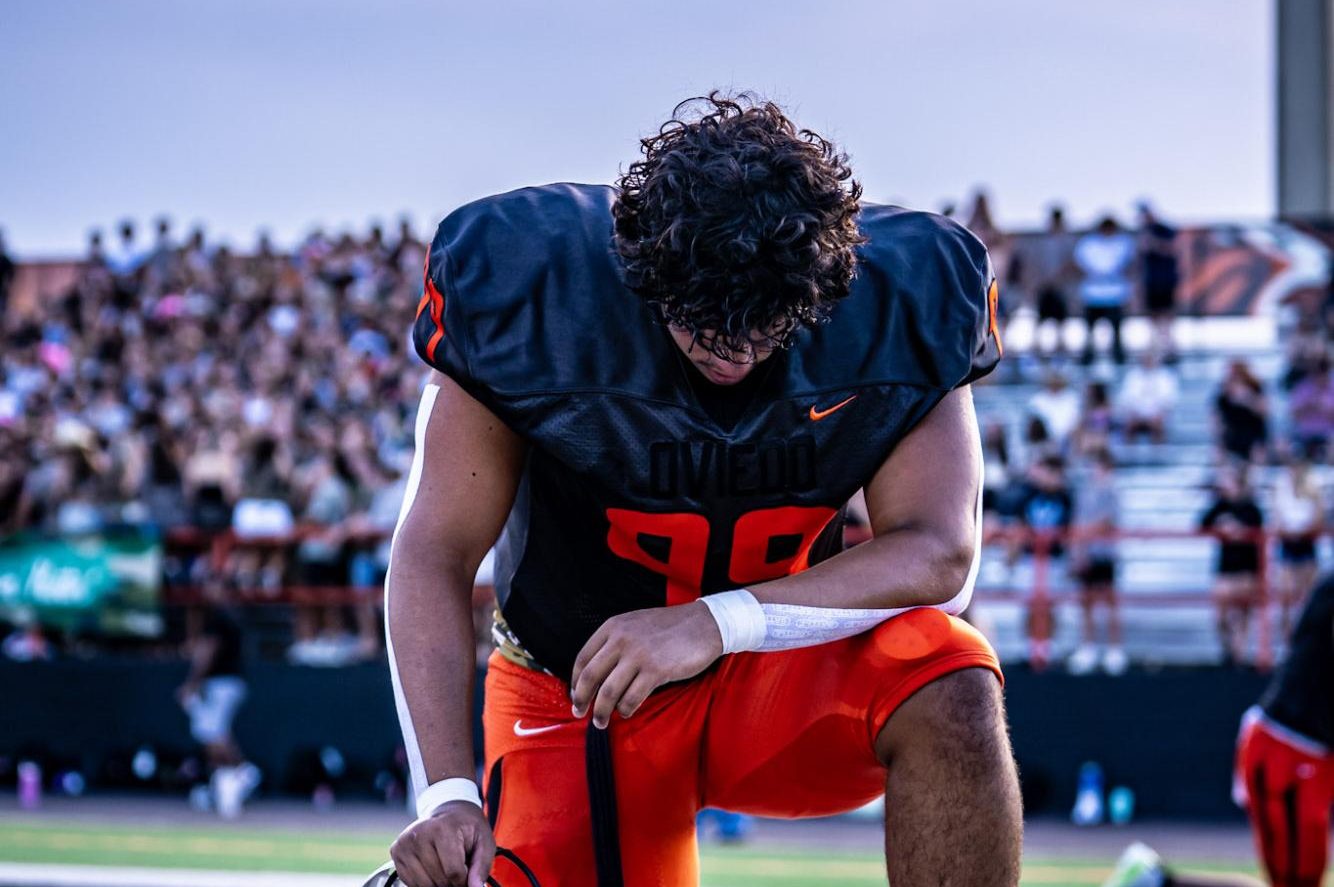 Senior Miguel Hernandez takes a knee in prayer before a game.