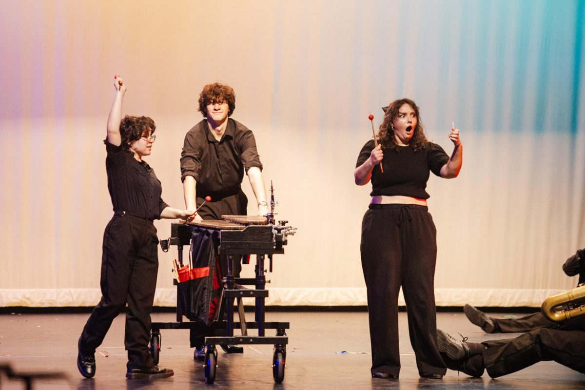 During the performance of "Officer Krupke," junior Alex Pedersen pushes the xylophone as junior Cal Culhane plays and senior assistant drum major Caroline Mann looks in shock at her broken mallet.
