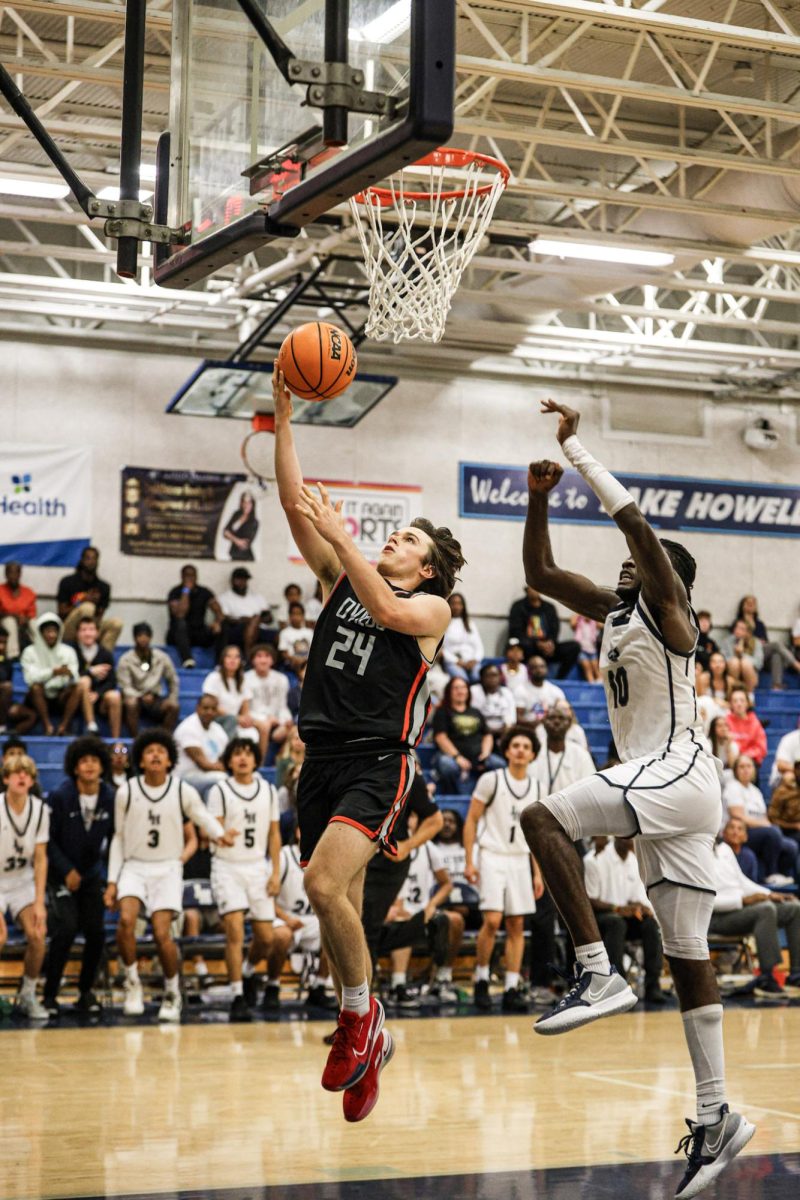 Captain and senior guard Conner Collins (24) shooting at the boys basketball game against Lake Howell High School on Dec. 4.