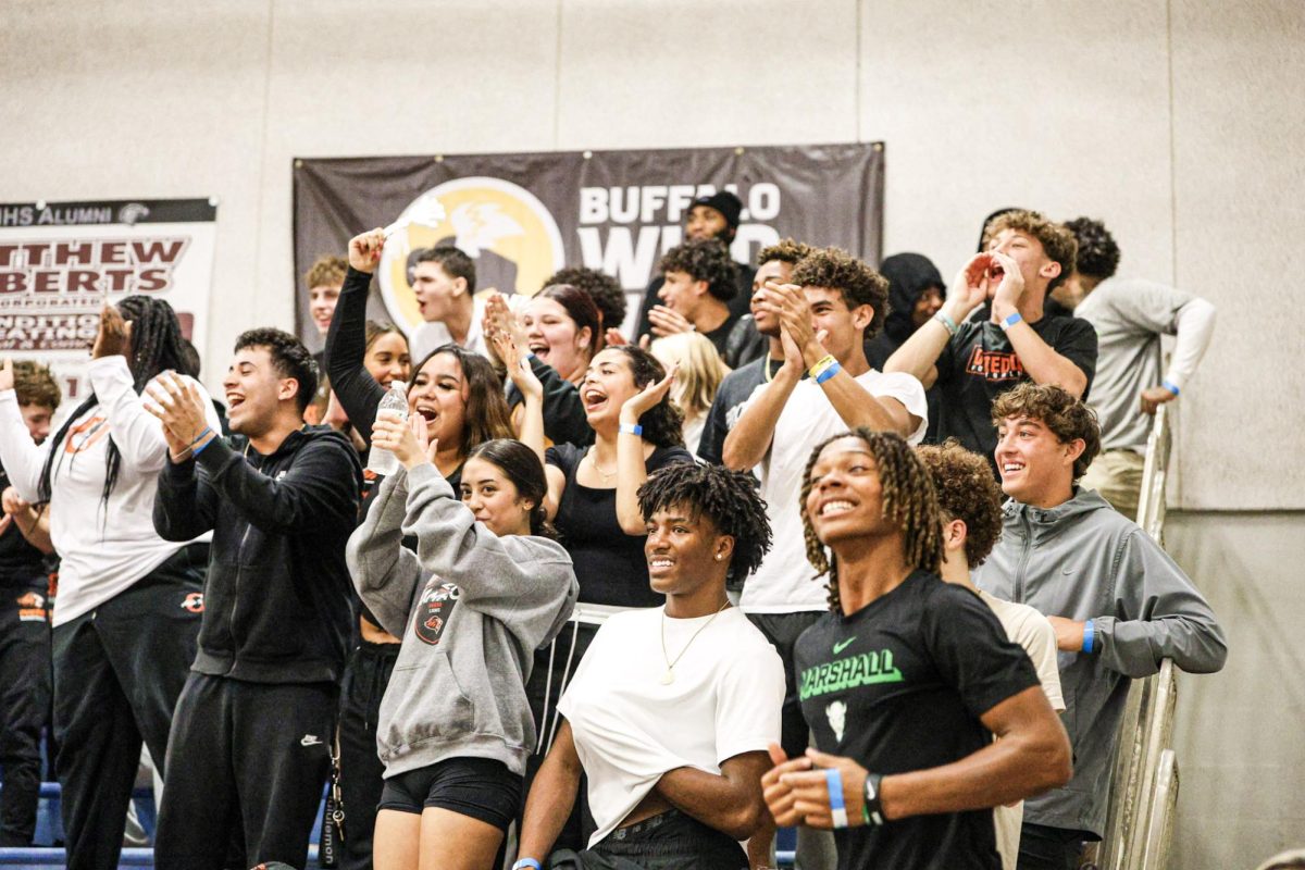 Oviedo High School students showing their support for the boys basketball team and cheering from the student section.