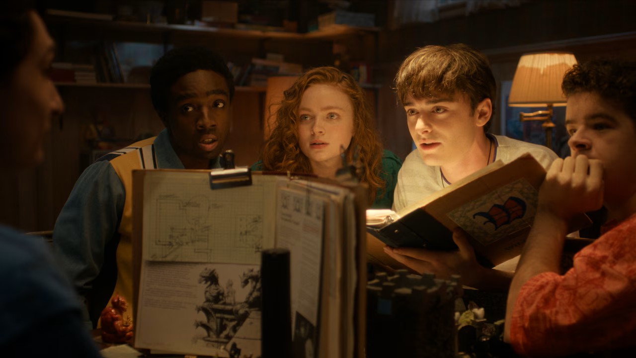Lucas Sinclair (Caleb McLaughlin), Max Mayfield (Sadie Sink), Will Byers (Noah Schnapp) and Dustin Henderson (Gaten Matarazzo) circle around Mike Wheeler (Finn Wolfhard) in a final D&D campaign before parting ways. Image courtesy of Netflix.