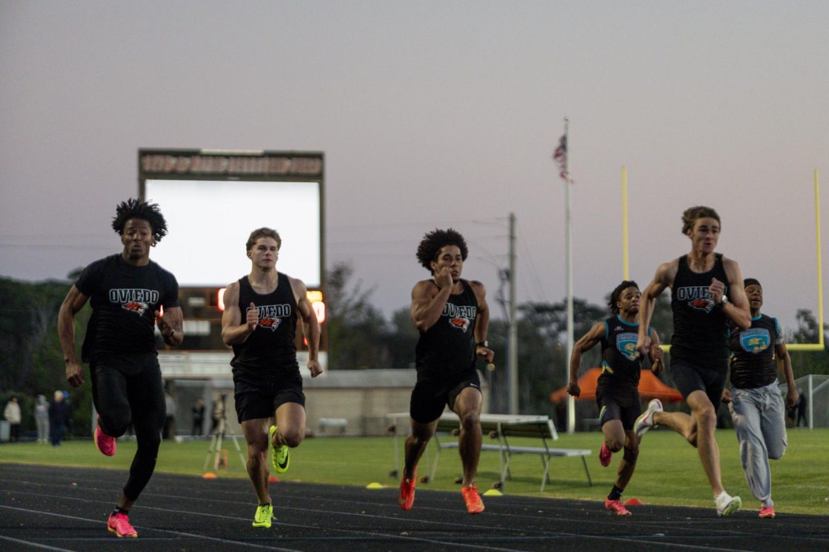 Oviedo seniors Dashon Febres, Brock Joyce, Emiliano Galarza, and Bruce Slivinski sprint together, overtaking opponents during a race.
