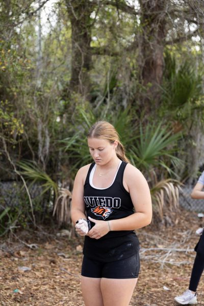 At the Lake Mary opener on March 14, Olivia Chapman adjusts her wrist brace on a chalked hand before throwing.