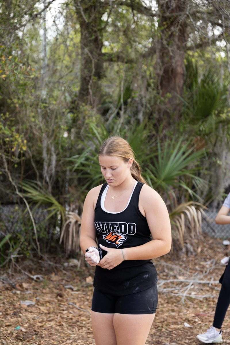 At the Lake Mary opener on March 14, Olivia Chapman adjusts her wrist brace on a chalked hand before throwing.