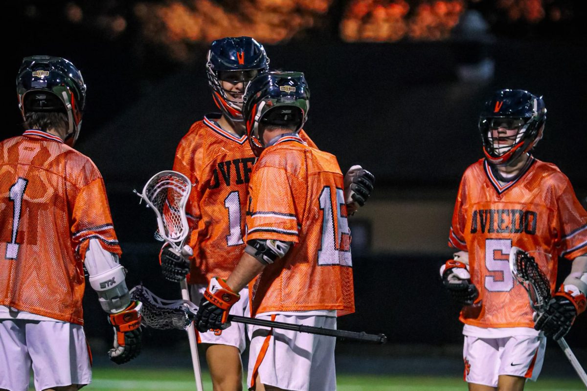 Sophomore Anthony Lunardi pats senior Kyler Black on the back. Coming in from the left and right are seniors Brandon Barlow and Kayden Blake.