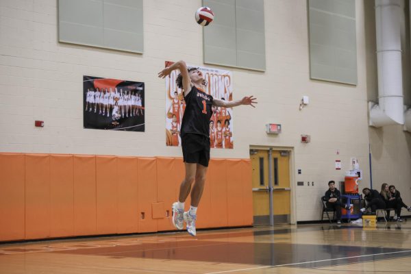 Junior John “Avery” Kader reaches to hit the ball over the net.
