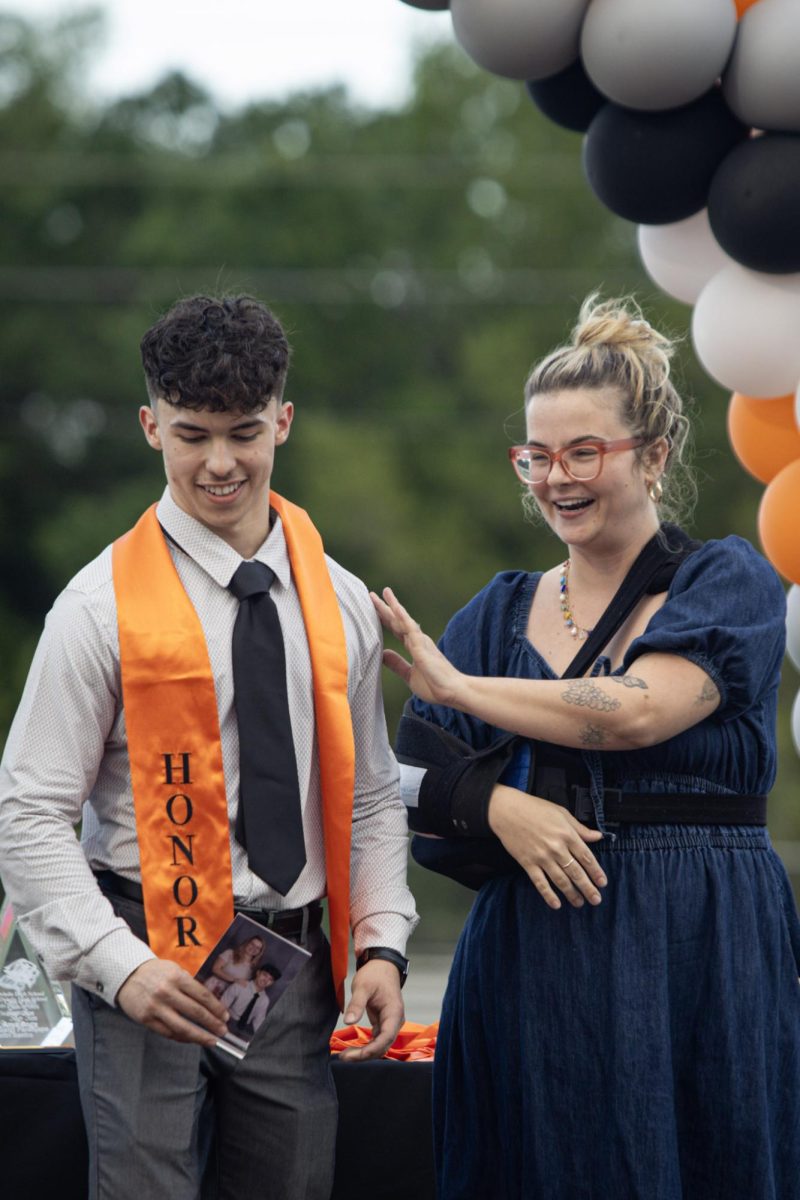 Biology teacher Kristin Jones pats Joshua Vargas on the back in congratulations.