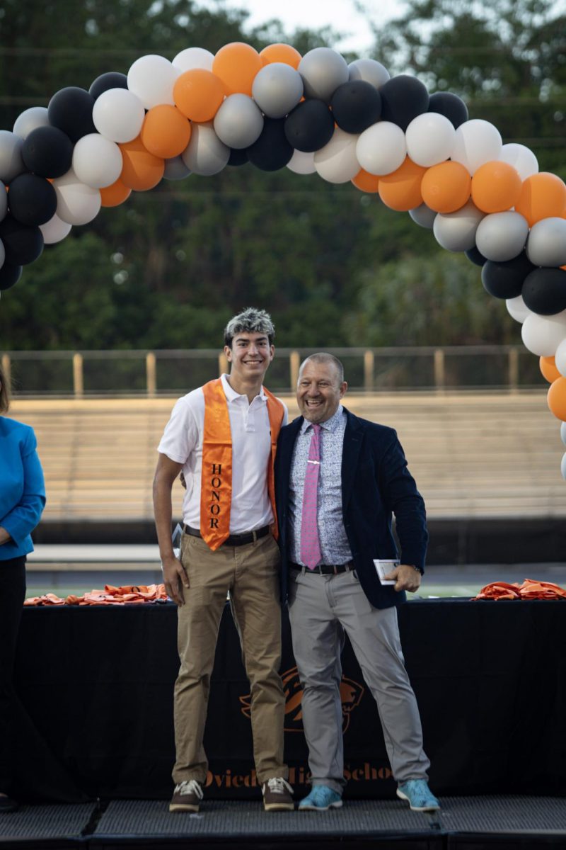 Physics teacher Chris Capp and Daniel Cunado pose for a photo, grinning.
